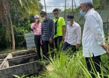 Tuan Ibrahim Tuan Man (dua dari kanan) melihat longkang besar yang tidak diselenggara dengan baik  di Pasir Tumboh, Kota Bharu hari ini -UTUSAN/ ROHANA MOHD NAWI