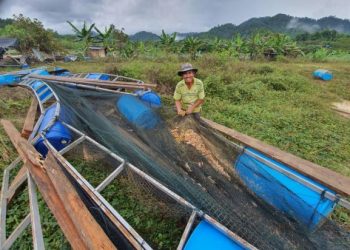 Norimi Jusoh menunjukkan sangkar ikan miliknya yang musnah akibat banjir di Kampung Darat Teladas, Air Putih di Kemaman, Terengganu hari ini.