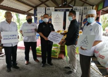 ABDUL Fattah (tengah) menyerahkan sumbangan kepada wakil Koperasi Keluarga Haji Sulaiman, Datuk Hanafi Sulaiman menerusi program Tanggungjawab Sosial Korporat (CSR) Coopcare di Bilik Gerakan Kampung Kuala Sawah, Rantau dekat sini hari ini.-UTUSAN/ZAKKINA WATI AHMAD TARMIZI.