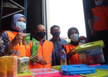 Rina (kiri) meninjau persiapan alatan dan makanan bagi persediaan bencana ketika mengadakan lawatan kerja di Depoh Simpanan Keperluan Bencana Zon Selatan, Muar. -UTUSAN/NUR ALINA HASSAN.