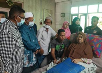 Hanafiah (kiri) bersama Mamad (dua, dari kiri) menziarahi keluarga SIti Nor Surya Ismail di Kampung Beladau Selat di Kuala Terengganu, Terengganu hari ini.