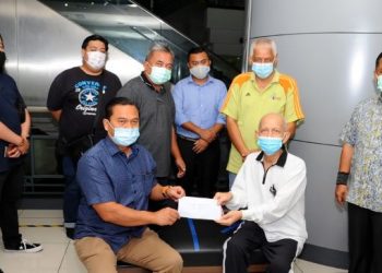 Dazar Sulaiman (duduk kanan)  menerima sumbangan daripada Mohamad Fauzi Ishak (duduk kiri)  di sebuah klinik di Johor Bahru di sini. - UTUSAN/RAJA JAAFAR ALI