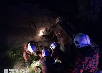 ANGGOTA bomba mengeluarkan mangsa maut yang dihempap keretanya yang terbalik di Teluk Intan hari ini. - GAMBAR IHSAM JBPM