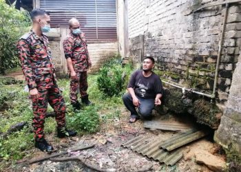 Mohd Haslim menunjukkan kesan kerosakan di bahagian dapur rumah keluarganya di Felda Mengkawang, Hulu Terengganu kepada Hanaffi (kiri).