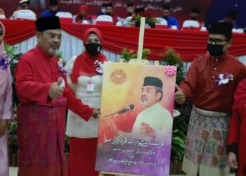 TAJUDDIN Abdul Rahman (kiri) menerima cenderahati daripada pimpinan UMNO Pasir Salak selepas merasmikan Mesyuarat UMNO bahagian itu di Chenderong Balai hari ini. - UTUSAN/SHAARANI ISMAIL