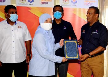 M. Saravanan (kanan) menyampaikan surat tawaran kerja di bawah Inisiatif Penjana HRDF kepada Amal Lidya Abdul Jalal  (dua dari kiri) pada Majlis Program Inisiatif Penjana HRDF, Peringkat Negeri Johor di Hotel Thistle di sini.
-UTUSAN/RAJA JAAFAR ALI