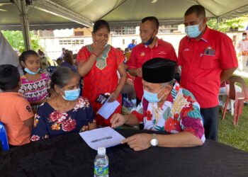 TOSRIN Jarvanthi (kanan) membantu penduduk membuat pendaftaran Yayasan Sejahtera Kulai dalam Program Mesra Prihatin Makmur Johor di Dataran Beringin, Kulai, Johor, semalam. - UTUSAN/BAAZLAN IBRAHIM