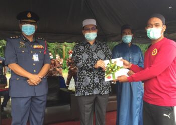 MD. Salleh Sarbini (kiri) menyaksikan Zuraidin Abdullah (tengah) menyerahkan sijil kepada anggota Pasukan Bomba Sukarela Mahaad Al-Balaghul Mubin, Rong Chenok yang menamatkan kursus persediaan banjir. - UTUSAN/YATIMIN ABDULLAH