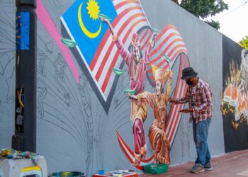 LAI Teo Kuang tekun menyiapkan lukisan muralnya yang terletak di Jalan Yam Tuan, Seremban.-UTUSAN/MUHAMMAD IZZAT TERMIZIE