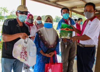 ISKANDAR Sarudin (kanan) menyampaikan sumbangan kepada penduduk Kampung Batu Tiga Mambau, Alimah Omar Ali yang terjejas akibat banjir kilat pada 4 November lalu.-UTUSAN/MUHAMMAD IZZAT TERMIZIE.