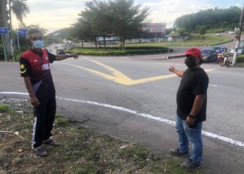 KAMARUHASHIM A. Kadir (kanan) dan Mat Lazim (kiri) menunjukkan persimpangan Jalan Besar yang sering belaku risiko kemalangan jalan raya.