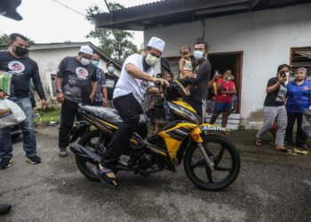 EBIT Lew menaiki motosikal yang dihadiahkan beliau kepada Amran (empat dari kanan).-
Gambar Facebook Ustaz Ebit Lew