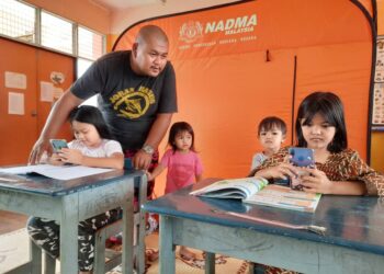 BAPA, Mohd. Iswandi Ishak menemani anaknya, Nur Fatrisya Iman (kiri) dan rakan anaknya, Safiaya Amirul Anwar yang mengikuti latihan PdP di PPS SK Malau, Jitra, Kubang Pasu hari ini.