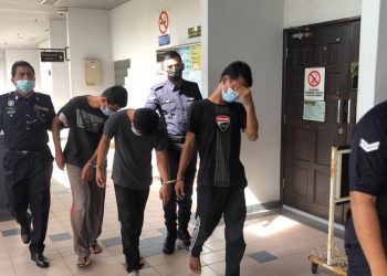 KETIGA-tiga tertuduh diiringi anggota polis selepas dihadapkan di Mahkamah Majistret Ayer Keroh di sini, hari ini. UTUSAN/ DIYANATUL ATIQAH ZAKARYA