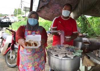 FAUZIAH Mustapa menunjukkan putu halba berinti serunding daging di gerainya di Kampung Penambang, Kota Bharu, Kelantan. - UTUSAN/ROSLIZA MOHAMED