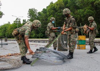 ANGGOTA Angkatan Tentera Malaysia (ATM) membuka kawat duri yang dipasang di sekitar kawasan Putra Point, Nilai, Negeri Sembilan yang sebelum ini dikenakan PKPD sejak 28 Oktober lalu. -UTUSAN/MUHAMMAD IZZAT TERMIZIE