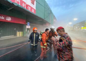 ANGGOTA bomba bertungkus lumus memadamkan kebakaran yang berlaku di sebuah pasar raya di Bahau dalam kejadian yang berlaku petang, semalam.-IHSAN BOMBA