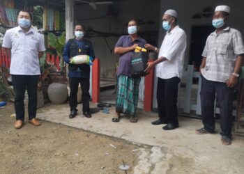 MAHADI Awang (dua kiri) bersama Wan Hassan Wan Ibrahim (dua kanan) menyampaikan sumbangan bungkusan makanan kepada seorang asnaf mangsa banjir di Kampung Gong Pasir, Pasir Puteh, Kelantan, hari ini.