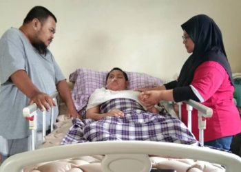 ARSYAD Ruzin (tengah) sedang disantuni ayahnya, Ruzin Supaat (kiri) dan ibunya, Mulyana Mokmin di rumah mereka di Sungai Kandis Klang Selangor hari ini.-UTUSAN/
ABDUL RAZAK IDRIS