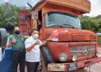 AHMAD Jazlan Yaakub (kanan) menunjukkan isyarat bagus selepas menampal notis peringatan di lori sebagai gimik kempen Pensijilan Minyak Sawit Mampan Malaysia (MSPO) kepada pekebun kecil dan pemain industri sawit di KWL Bina Jaya Sdn. Bhd. di Raub, Pahang hari ini.