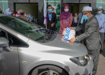 Alias menampal pelekat pada sebuah kereta yang digunakan dalam perkhidmatan Homecare Services di pekarangan Hospital Pakar Kuala Terengganu (KTSH) di Kuala Terengganu hari ini. -UTUSAN/Puqtra Hairry Rosli