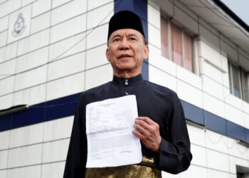 MOHD. Annuar Zaini menunjukan laporan polis berhubung kenyataan yang memfitnah beliau berkaitan pelantikan exco Perak di Balai Polis Kampung Rapat di Ipoh hari ini. - UTUSAN/ZULFACHRI ZULKIFLI