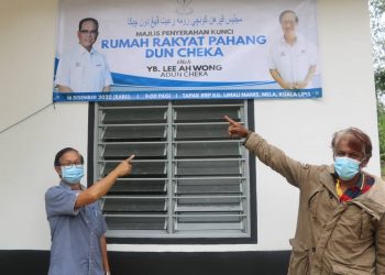 LEE Ah Wong (kiri) dan Ismail Mohd. Nor menunjukkan kain rentang projek Rumah Rakyat Pahang (RRP) di Kampung Limau Manis, Mela Lipis, Pahang hari ini. -UTUSAN/ SALEHUDIN MAT RASAD