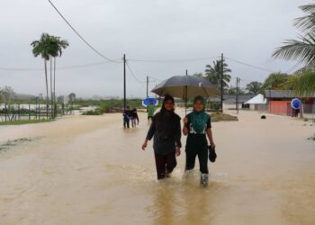 BEBERAPA remaja mangambil peluang mengharung banjir di Kampung Padang Kubu di Kemaman hari ini. -UTUSAN/ NIK NUR IZZATUL HAZWANI NIK ADNAN