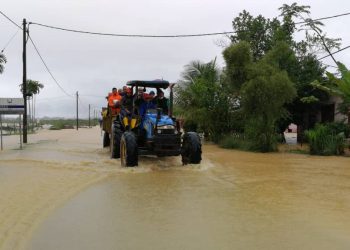 KHIDMAT traktor digunakan bagi membawa mangsa banjir di Kampung Padang Kubu di Kemaman ke pusat pemindahan sementara (PPS) di balairaya kampung itu.-UTUSAN/ NIK NUR IZZATUL HAZWANI NIK ADNAN