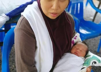 SUHAILA Ariffin dan bayi lelakinya yang berusia tujuh hari dibawa ke PPS Padang Kubu di Kemaman buat sementara selepas jalan masuk ke rumahnya ditenggelami banjir, hari ini.-UTUSAN/ NIK NUR IZZATUL HAZWANI NIK ADNAN