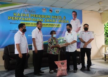 MOHD. Salim Mohd. Sharif (dua, dari kanan) menyampaikan bantuan zakat kepada penerima dalam majlis Majlis Kasihi Pekebun dan Penyampaian Zakat Risda Negeri Sembilan 2020 di Kampung Orang Asli Panchor, Jempol hari ini.-UTUSAN/BADRUL HAFIZAN MAT ISA