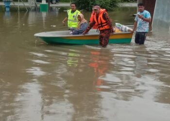 BOMBA membantu penduduk berpindah di Kampung Kemasik, Kemaman semalam. -UTUSAN/ NIK NUR IZZATUL HAZWANI NIK ADNAN