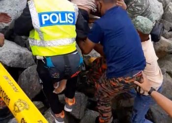 ANGGOTA bomba bersama polis dan orang ramai membawa mayat mangsa lemas Zahrawi P. Ramlee di Tanjung Piai, Pontian, Johor.