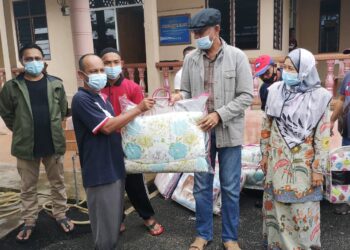 ROSOL Wahid menyerahkan sumbangan kepada mangsa banjir di pusat pemindahan sementara (PPS) Kampung Menerong di Ajil, Hulu Terengganu hari ini