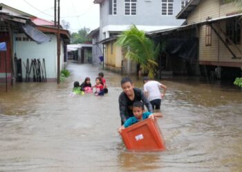 KANAK-kanak tidak melepaskan peluang bermain air banjir di Kampung Tempurung di Kemaman hari ini. - UTUSAN/NIK NUR IZZATUL HAZWANI NIK ADNAN