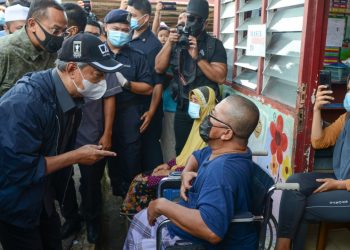 MUHYIDDIN Yassin (kiri) berbual dengan Ismail Mamat, 56, di pusat pemindahan sementara (PPS) di Sekolah Kebangsaan (SK) Bukit Mentok di Kemaman hari ini.