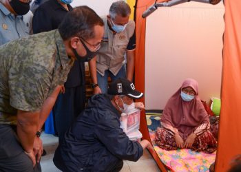 MUHYIDDIN Yassin (kiri) bertanya khabar Rosidah Abd. Razak, 53, di pusat pemindahan sementara (PPS) di Sekolah Kebangsaan (SK) Bukit Mentok di Kemaman hari ini.