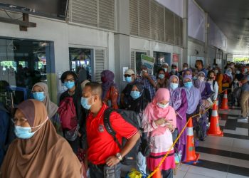 SEBAHAGIAN penumpang beratur panjang menunggu giliran untuk menaiki feri ke Pulau Langkawi di pintu masuk utama Terminal Feri Kuala Perlis bulan lalu. UTUSAN/SHAHIR NOORDIN