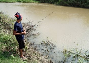 SEORANG penduduk memancing di Sungai Tumboh di Kampung Gajah semalam iaitu lokasi yang tular kejadian ribuan ikan mati baru-baru ini. - UTUSAN/ZULFACHRI ZULKIFLI