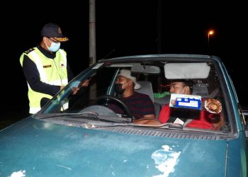 MOHAMMAD Yusoff Abustan  memeriksa pemandu kereta dalam Operasi Bersepadu Ambang Tahun Baharu di Ipoh semalam. - UTUSAN/ ZULFACHRI ZULKIFLI