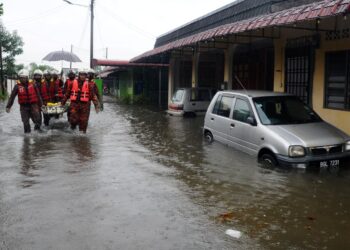 ANGGOTA bomba mengangkat salah seorang mangsa banjir selepas kediamannya dinaiki air dalam kejadian di Kampung Pasir, Skudai petang semalam. - UTUSAN/RAJA JAAFAR ALI