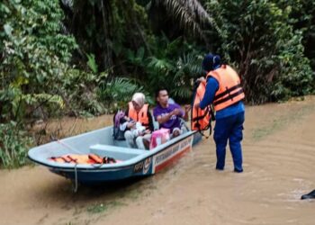 ANGGOTA Angkatan Pertahanan Awam Malaysia (APM) membantu memindahkan mangsa yang terjejas selepas rumah mereka dinaiki air di Kampung Jara, Maran, Pahang semalam.