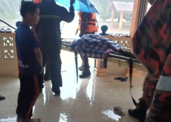 ANGGOTA bomba mengangkat mayat wanita yang lemas selepas terjatuh ke dalam longkang di Jalan Setia, Kampung Contoh, Kluang hari ini. - IHSAN BOMBA