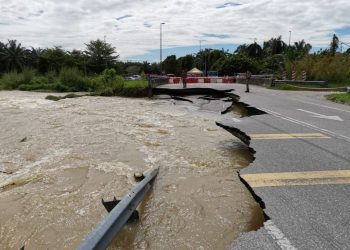 KEADAAN jalan yang runtuh akibat banjir di Jalan Chikus di Langkap, Teluk Intan menyebabkan laluan itu ditutup sejak semalam. - UTUSAN/AIN SAFRE BIDIN