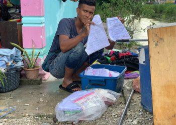 MUHAMMAD Alif Bedrul Hisham menunjukkan buku nota miliknya yang rosak akibat banjir yang melanda rumahnya di Pekan Chikus di sini hari ini. - UTUSAN/ASLIZA MUSA