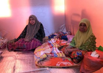 MUNAH Mamat (kanan) bersama anak saudaranya menjadi mangsa banjir terawal yang berpindah ke PP Kampung Sireh, Kota Bharu. -UTUSAN/ ROSLIZA MOHAMED