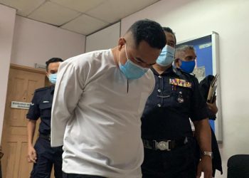 TERTUDUH, Mohd. Yazzid Ahmad (kiri) dibawa keluar dari Mahkamah Sesyen Johor Bahru selepas dituduh terlibat dalam aktiviti pengubahan wang haram berjumlah RM2.45 juta di Johor Bahru, Johor.