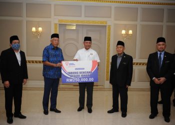 MAHDZIR Khalid menyampaikan replika cek bantuan berjumlah RM250,000 oleh Tenaga Nasional Berhad kepada Hasni Mohammad di Pejabat Menteri Besar di Bangunan Kota Iskandar, Johor Bahru hari ini.