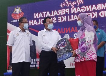 OSMAN Sapian (tengah) menyampaikan bantuan pakaian sekolah dalam Majlis Sumbangan Peralatan Murid Kembali Ke Sekolah di Dewan Raya Kempas, Johor Bahru, Johor. - UTUSAN/ BAAZLAN IBRAHIM