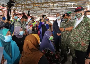 ISMAIL SABRI Yaakob (kanan) beramah mesra dengan mangsa banjir di PPS Sekolah Kebangsaan (SK) Bukit Mentok di Kemaman hari ini. -UTUSAN/ NIK NUR IZZATUL HAZWANI NIK ADNAN